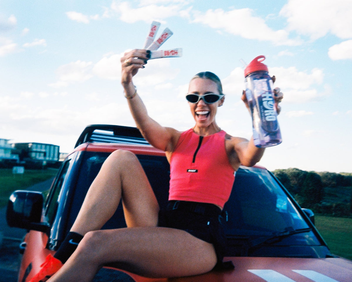 Sarah's Day on the Hyro Defender holding Blackcurrant Crush sticks and a bottle