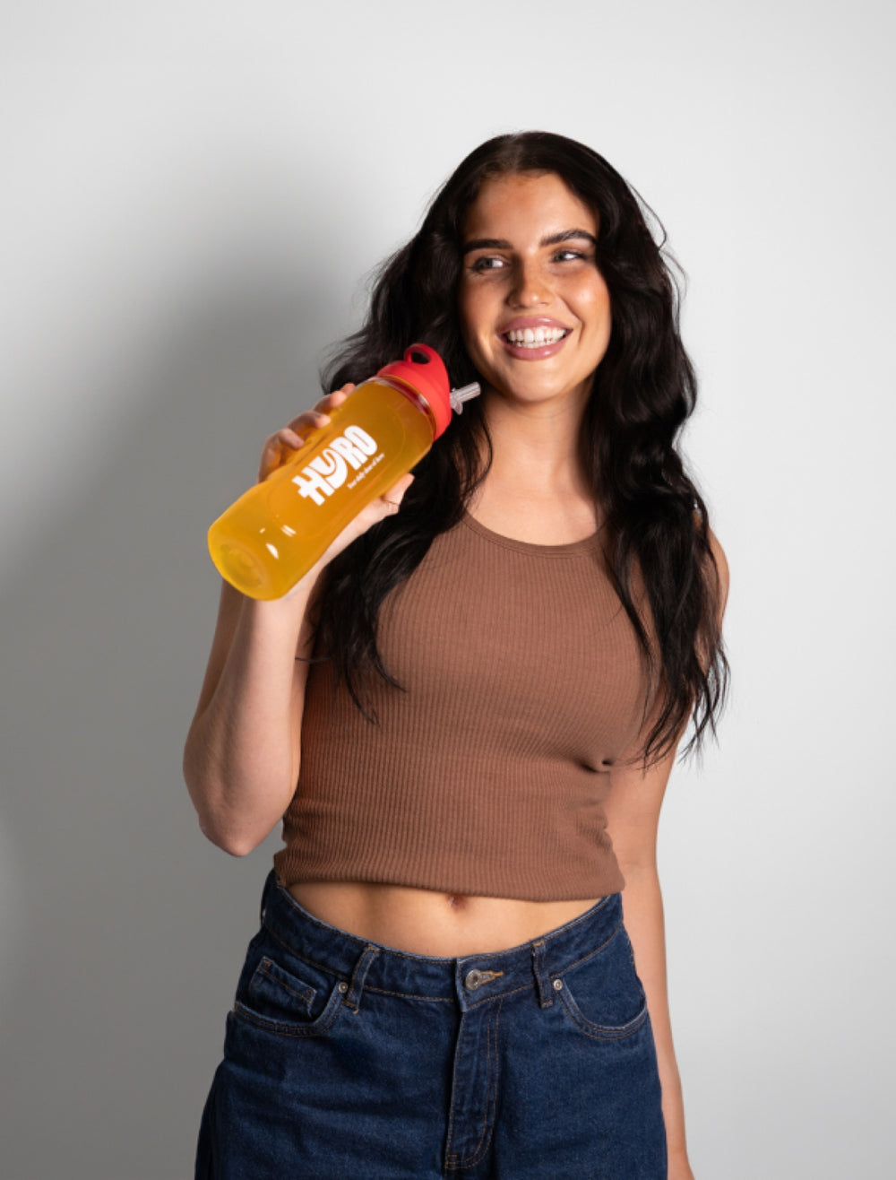 Woman in workout gear taking a selfie on a suburban Australian street holding a Hyro bottle