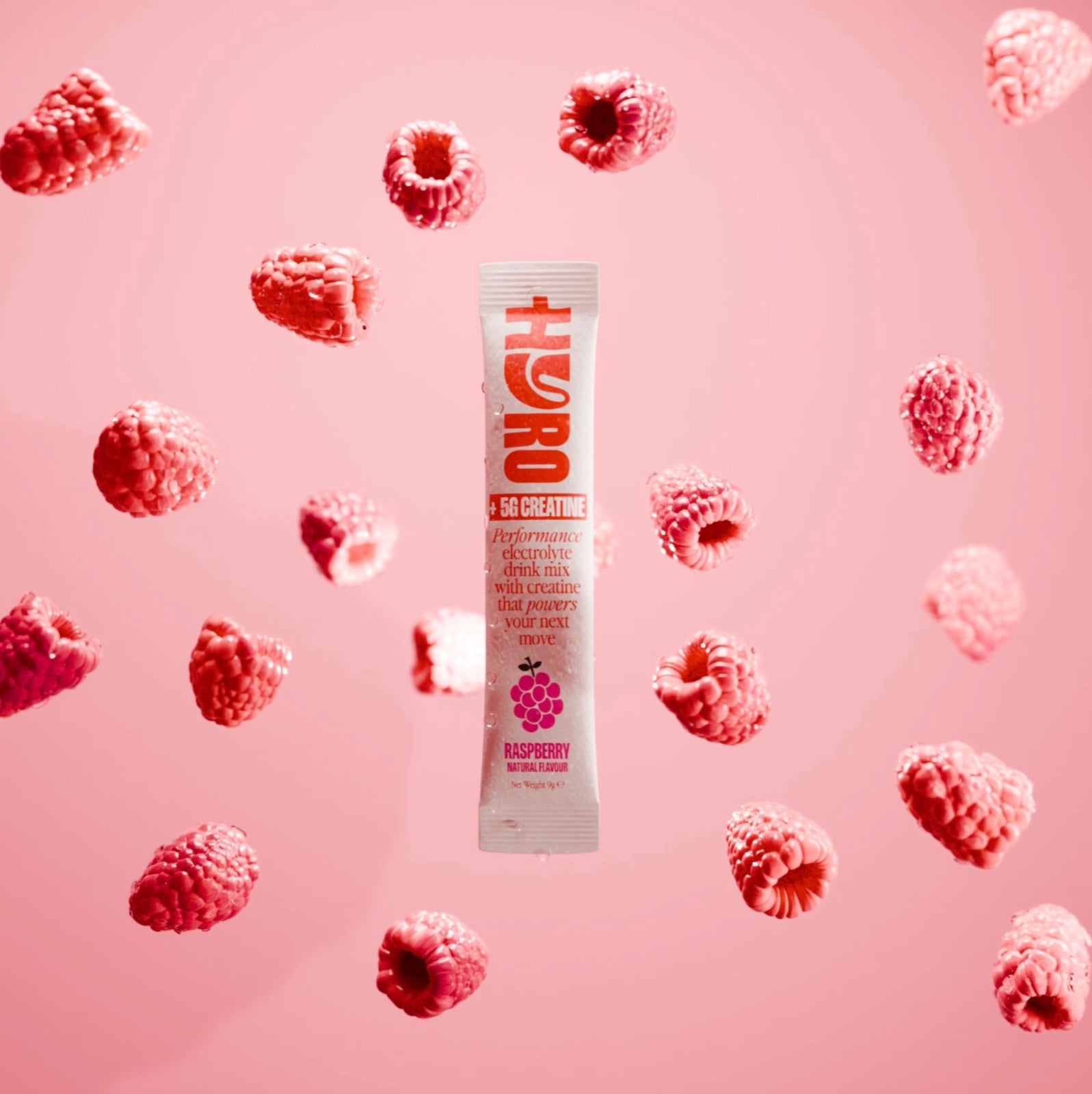 Hyro Raspberry electrolyte stick with 5g creatine, floating among raspberries