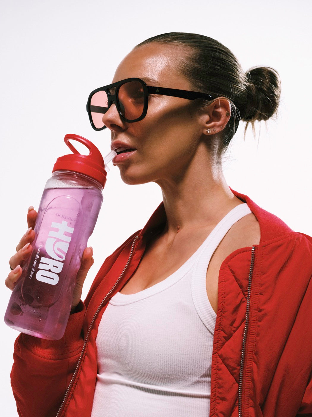 Woman in sunglasses drinking from a Hyro bottle of Electrolytes + Creatine